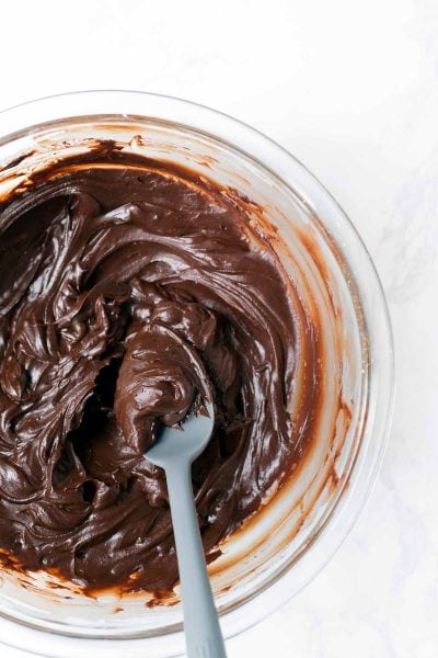 Homemade Chocolate Frosting in a bowl with a spoon.