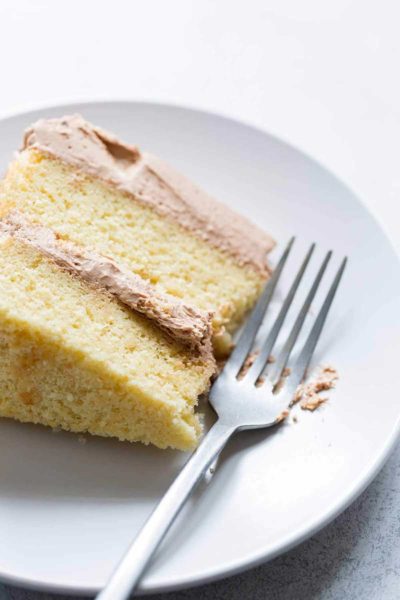 A slice of yellow cake with chocolate buttercream