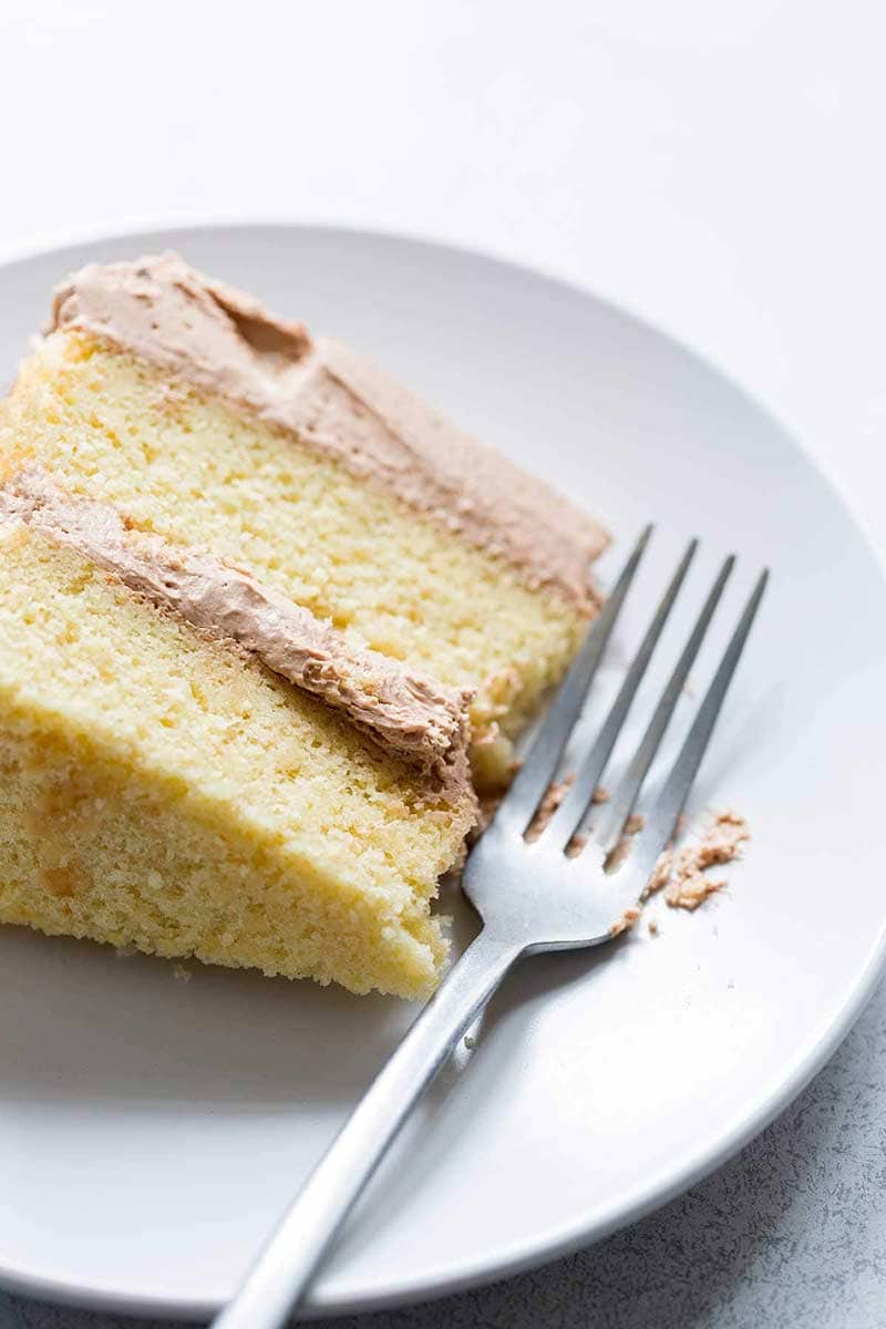 A slice of yellow cake with chocolate buttercream