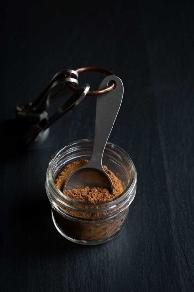 Pumpkin Pie Spice Mix in a mason jar with measuring spoons