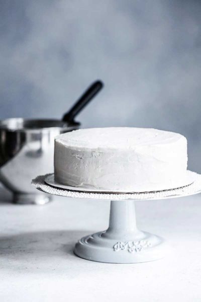 frosted homemade white cake on cake stand