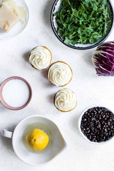 Foods representing the five tastes, including arugula, coffee beans, cupcakes, salt and parmesan.