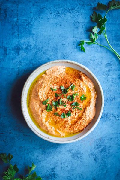 Learn how to make this smokey roasted red pepper hummus recipe at home! You won’t believe how easy it is, and it tastes worlds better than pre-packaged hummus.
