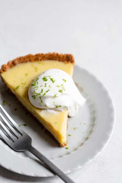 A slice of key lime pie topped with whipped cream