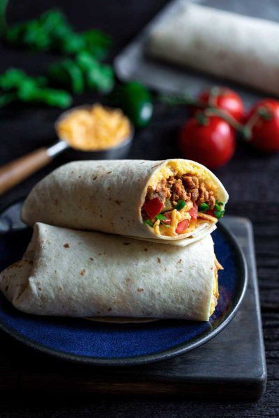 Closeup of breakfast burrito recipe with the end sliced off to show the filling