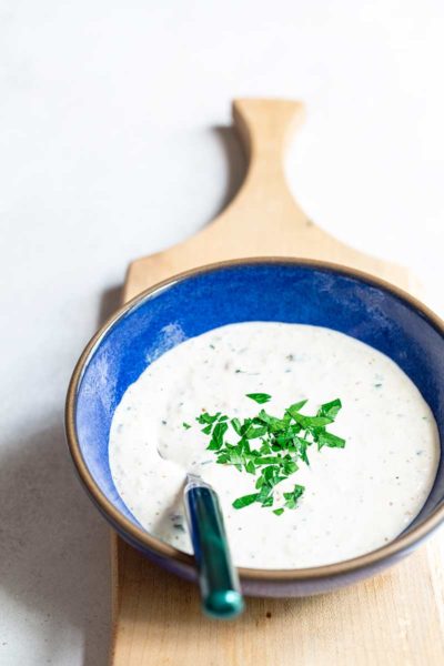 homemade horseradish sauce topped with chopped parsley in blue bowl