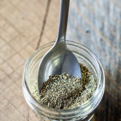 Homemade Italian Seasoning in a mason jar with a spoon