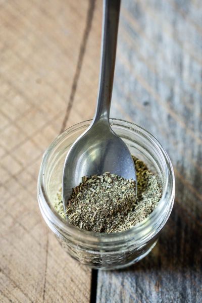 Homemade Italian Seasoning in a mason jar with a spoon