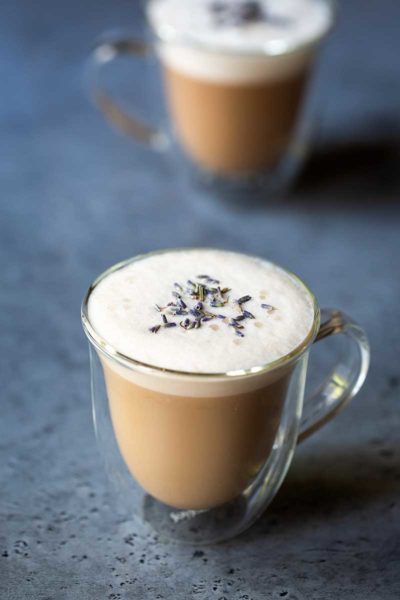 London Fog drink (tea latte) in a clear mug, topped with dried lavender