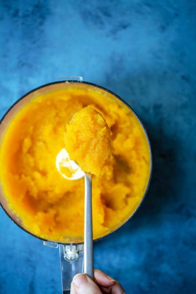 Homemade pumpkin puree in a food processor with a spoon