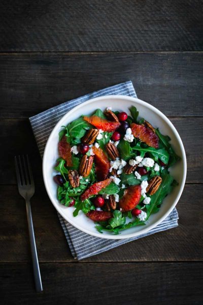Cranberry orange salad recipe in a salad bowl with a fork and napkin
