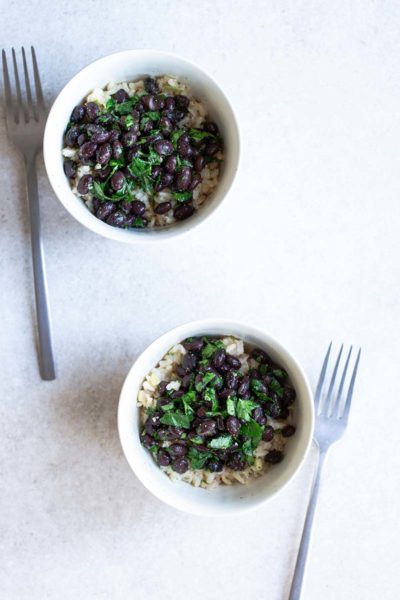 Black beans and rice recipe in a bowl next to a fork.