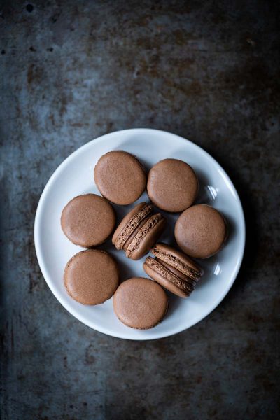 Sea salt chocolate macarons on a white plate