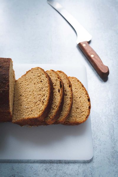 Sliced oatmeal molasses bread on a cutting board